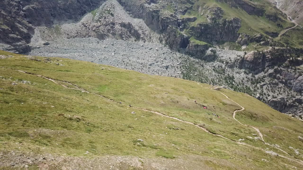 Prati erbosi in una valle delle Alpi svizzere, vista aerea con drone, paesaggio naturale di montagna, sentiero escursionistico per escursionisti e ciclisti