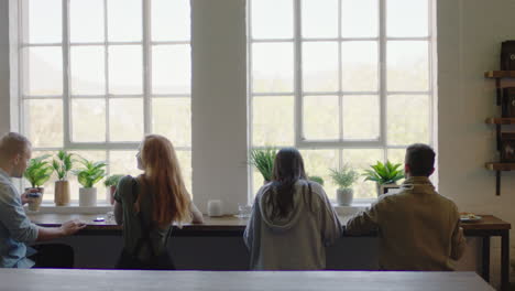 group of multi ethnic friends drinking coffee together in cafe talking having conversation enjoying socializing on lunch break in restaurant shop