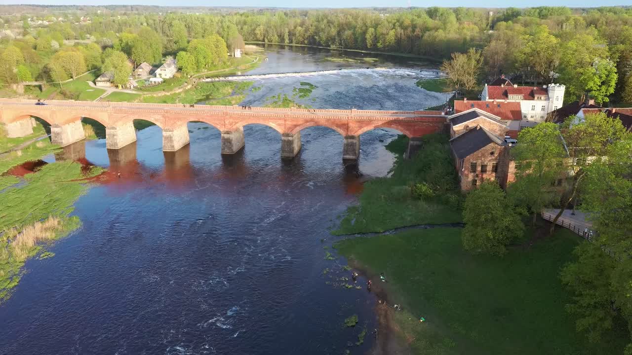 largo puente de ladrillo antiguo, kuldiga, letonia a través del río venta