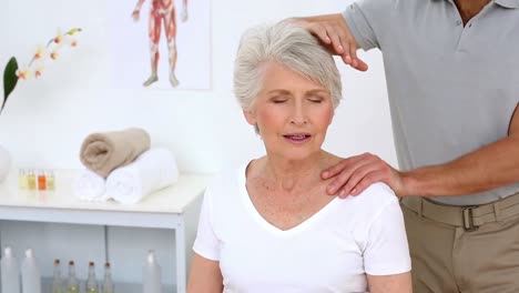 physiotherapist stretching senior patients neck