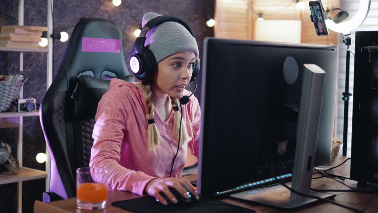 una streamer emocionada en su habitación jugando videojuegos en línea con amigos en línea. una adolescente está deseando ganar jugando un videojuego en línea en casa