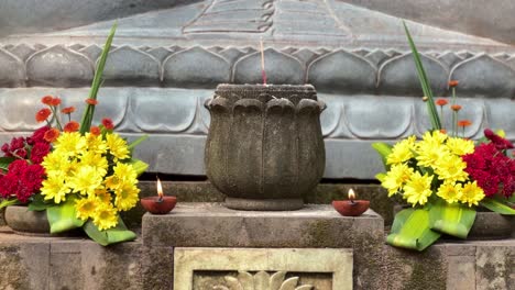 Burning-candles,-and-blooming-flowers-in-old-monastery,-close-up