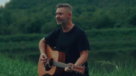 man playing acoustic guitar outdoors