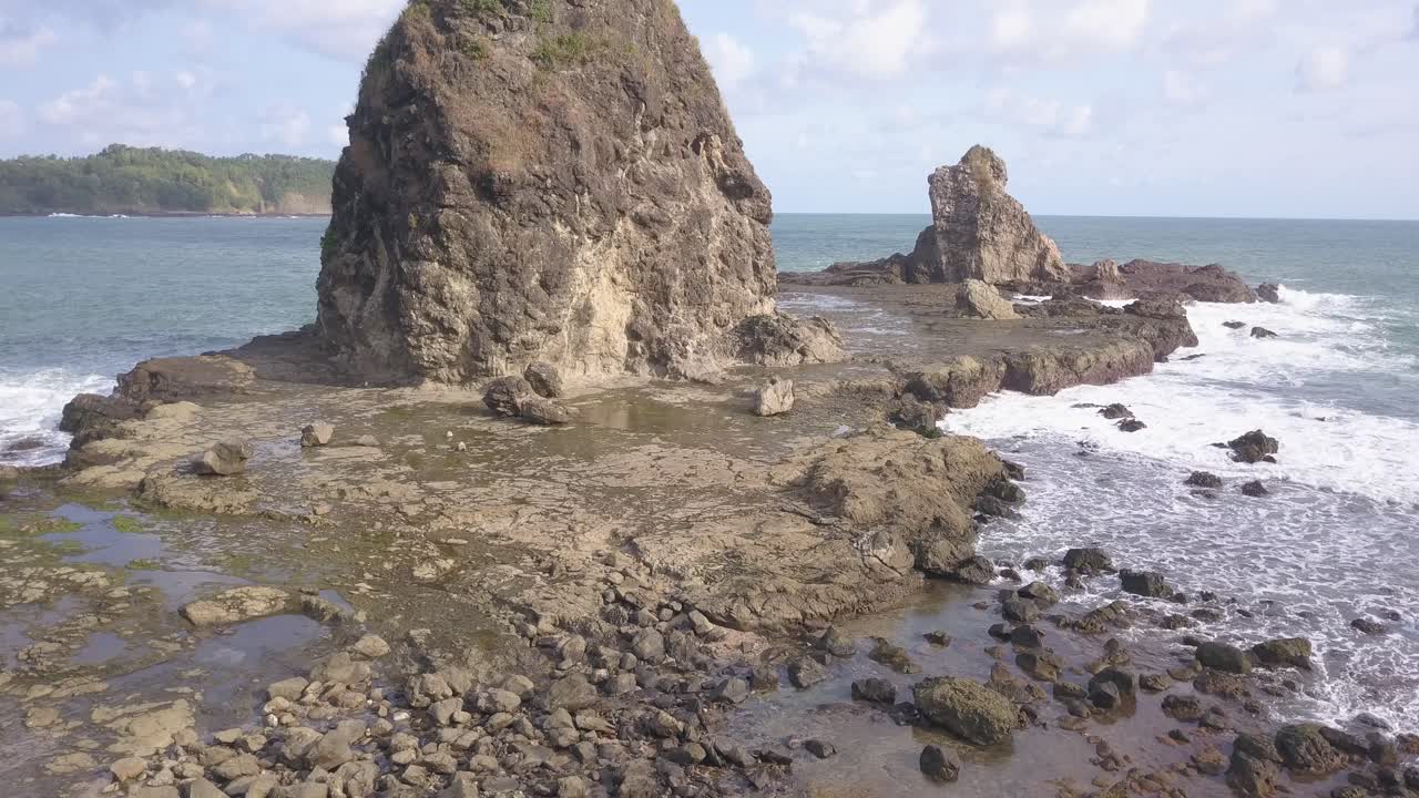 Watu Lumbung Beach in Gunungkidul, Yogyakarta. A beach with unique large rocks and corals. The waves crash against each coral.