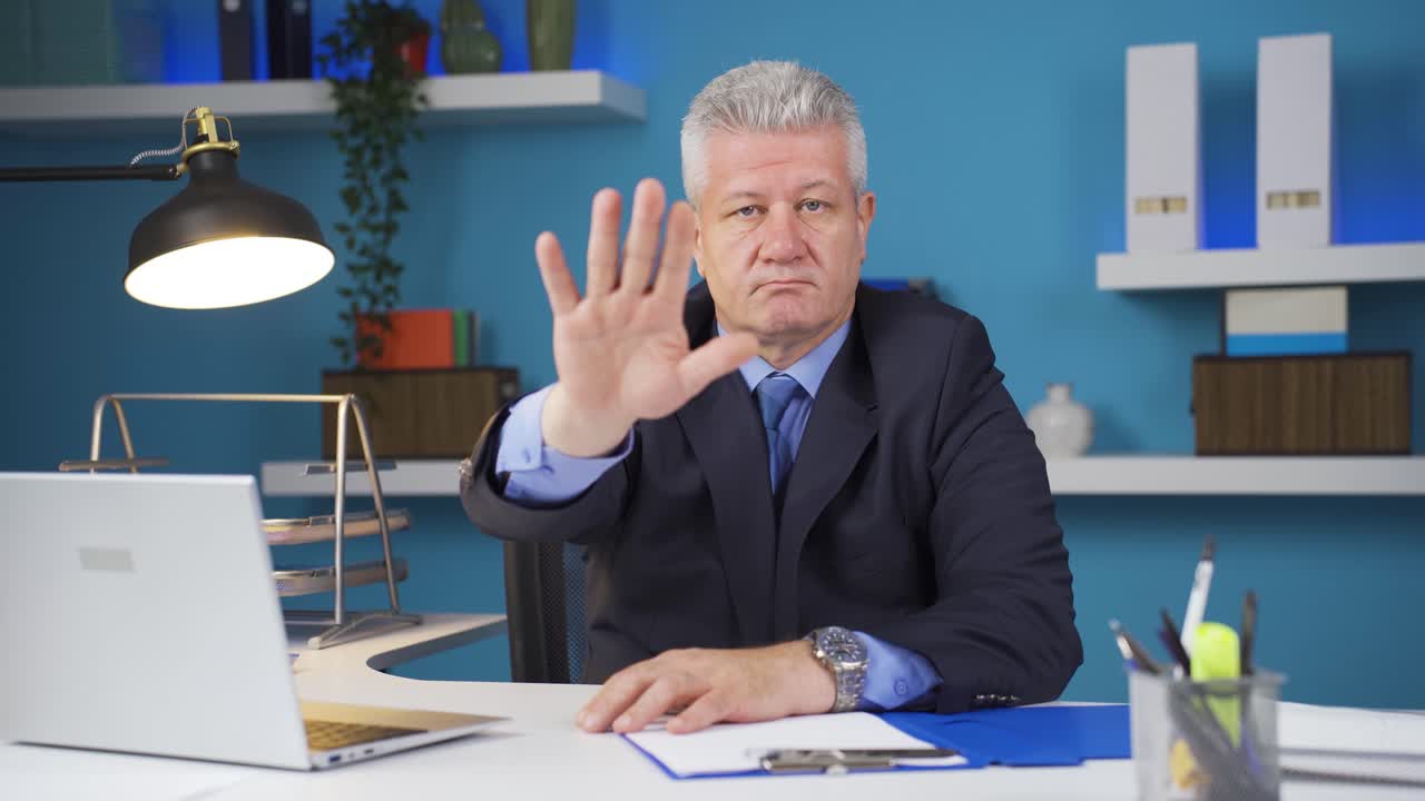 Businessman saying stop to camera.