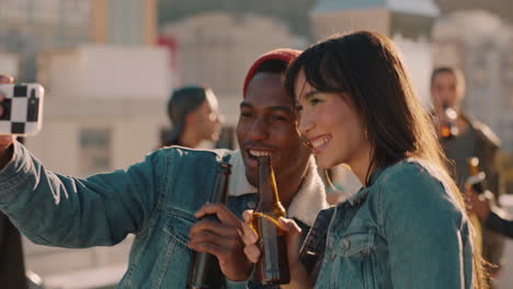 multiracial friends posing for selfie photo enjoying rooftop party celebration having fun sharing weekend in city on social media