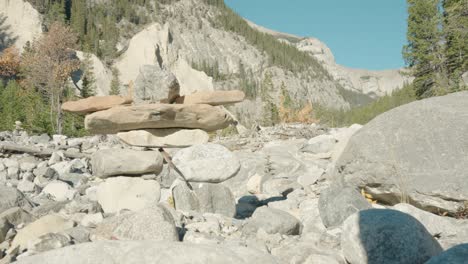 a largeman made rock inuksuit statue in a dried up river bed in the bright sun