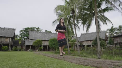 woman in traditional clothing walking through a rural village