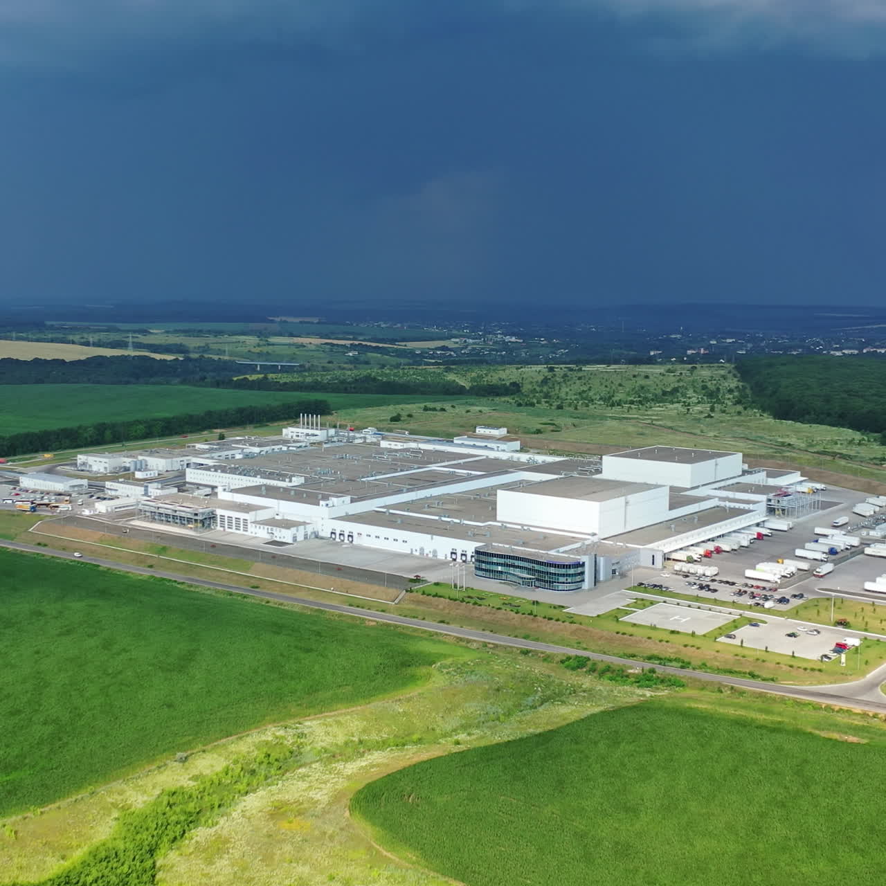 Huge industrial plant among natural green environment. Aerial footage of a large industrial complex.