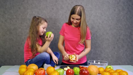 mother with daughter making salad. daughter and mother together preparing healthy organic food