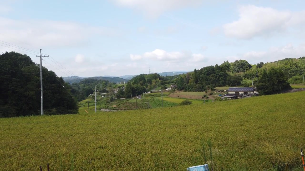 岡山県の田んぼ、家々、山々、田園風景をパンニングするハイアングルショット。日本の里山風景。