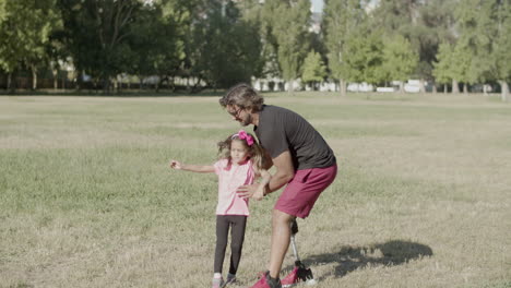 Long-shot-of-dad-with-disability-putting-daughter-on-shoulders