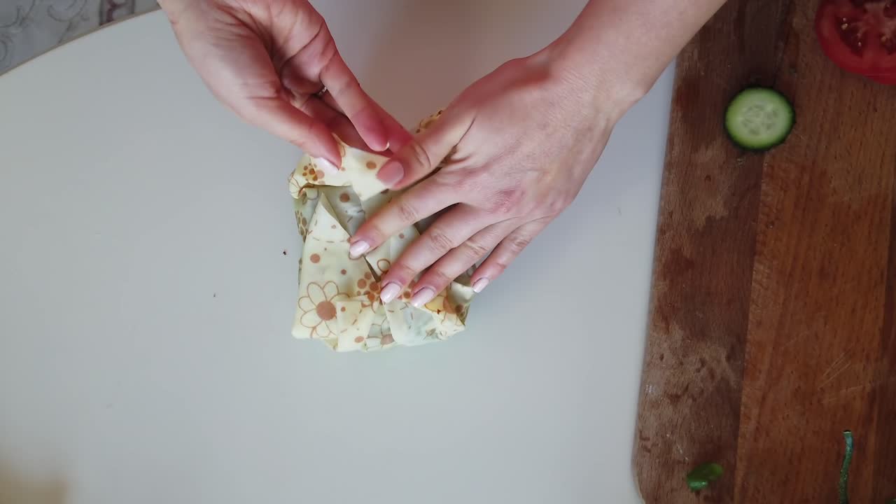 Close up of a woman making a sandwich on a wooden cutting board