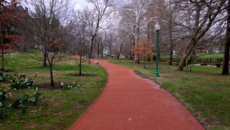 Red-brick-walking-path-on-the-campus-of-Indiana-University-in-Bloomington,-Indiana-with-gimbal-video-walking-forward