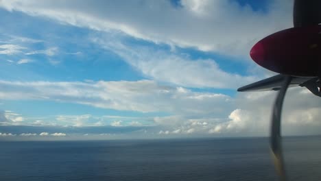 airplane propeller and clouds landing with ocean in background