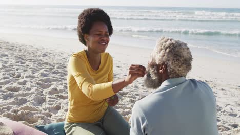 Glückliches-Afroamerikanisches-Paar-Beim-Picknick-Am-Sonnigen-Strand