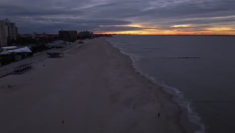 un lapso de tiempo aéreo sobre la playa de coney island, ny durante un amanecer nublado y colorido