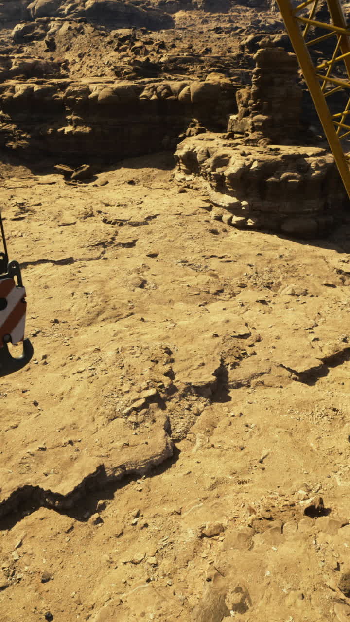 Heavy machinery operates in rugged terrain during daylight hours