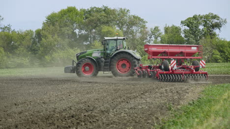 tractor with trailer seeder sowing cultivated field. agricultural machinery