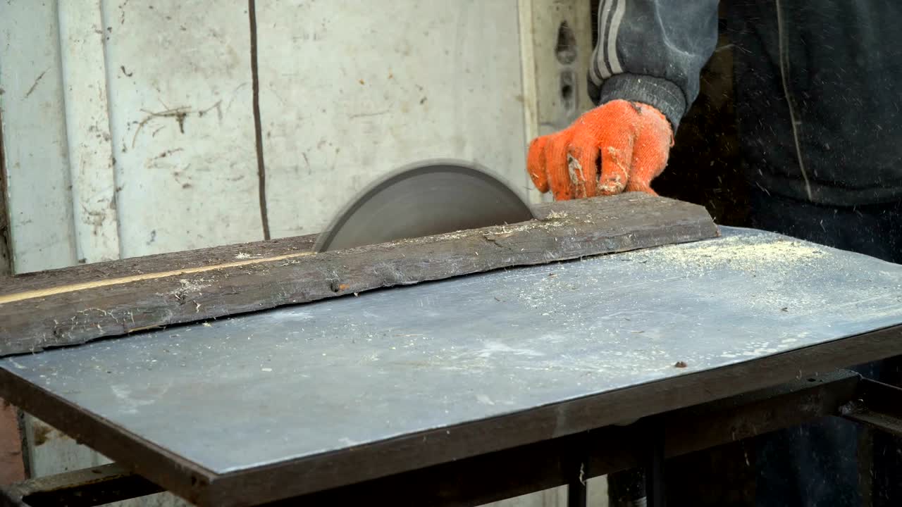 sierra circular. el mago corta una tabla de madera en una sierra circular, primer plano.