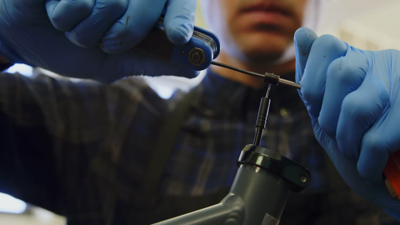hombre reparando una bicicleta en el taller 4k