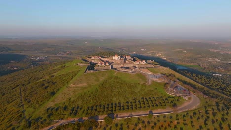 aerial orbit shot of cars driving uphill to famous castle named nossa senhora da graça fort in portugal