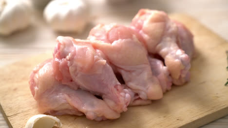 alitas de pollo crudas frescas en tablero de madera con ingredientes
