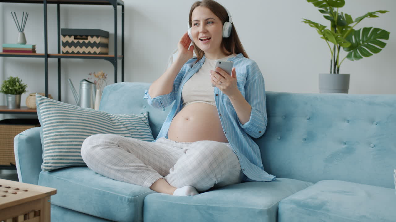 Pregnant Woman Listening to Music on Couch