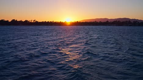 Slow-motion-waves-at-sunset,-handheld