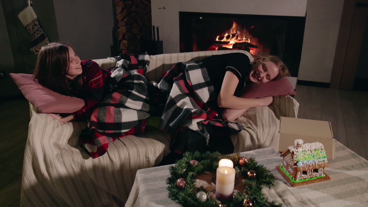 Two Women Relaxing by the Fireplace at Christmas