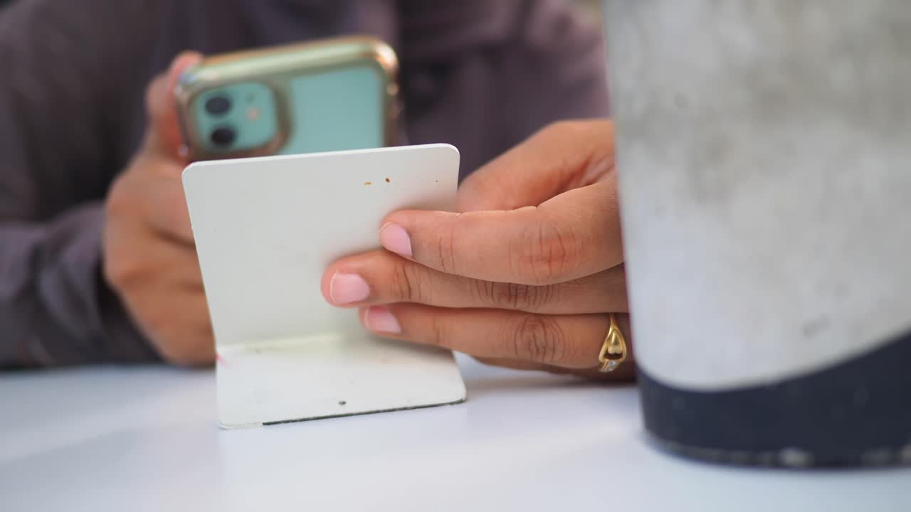 Hands holding a card and mobile phone