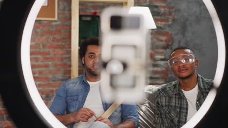 hombre afroamericano con un amigo habla con el vlog de reparación de cámaras
