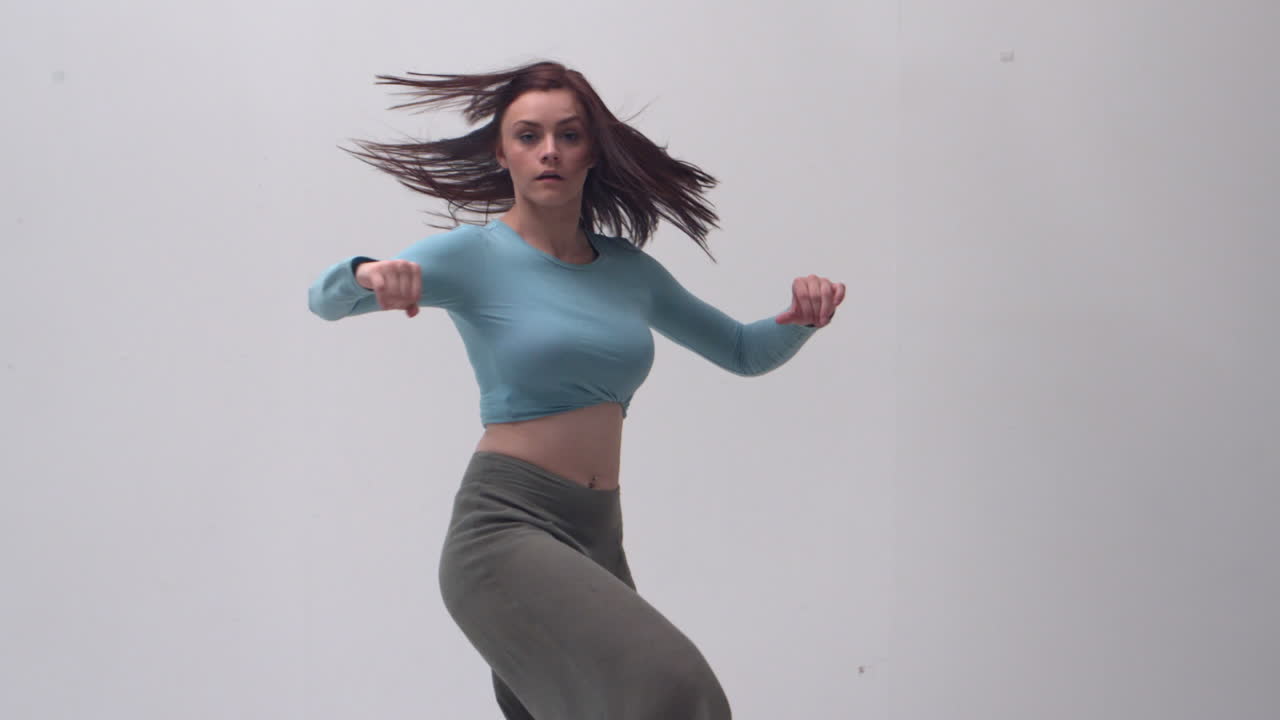 una joven encantadora saltando y volviéndose contra sí misma.