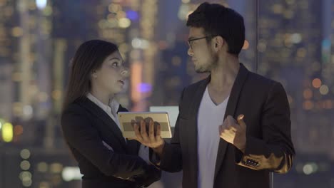 multi-ethnic team of business people working with a tablet. looking at screen and talking business.