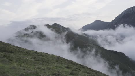 time-lapse clouds in the valley, mountains at the background, cloudy sky, meadow, static shot