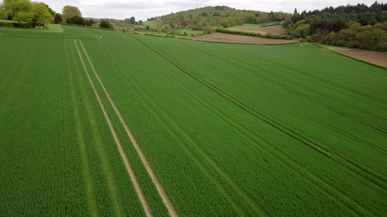 Drone flying over green field-hill