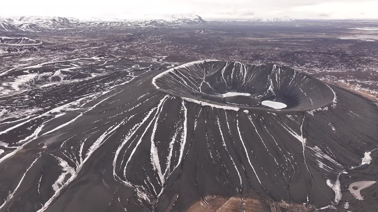 aerial snow streaks over dark volcanic Hverfjall crater near Mývatn lake in northern Iceland