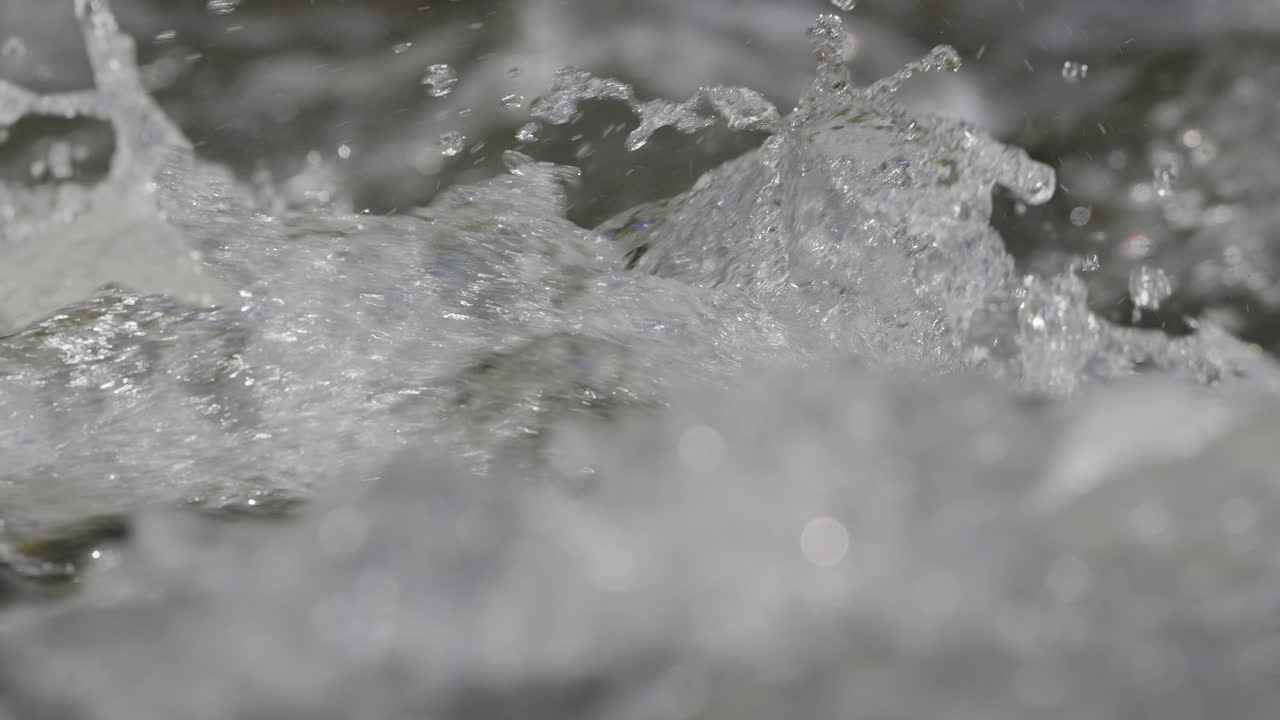 De l’eau dans une rivière qui coule rapidement au ralenti et en macro