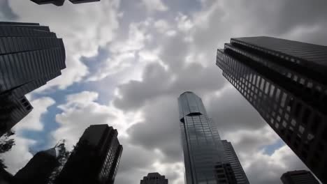 dramatic perspectives of urban architecture showcases towering skyscrapers beneath a dynamic cloudy sky, highlighting modern design and city life