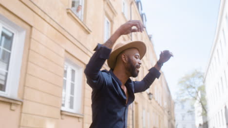 uomo afro-caraibico sorridente con cappello panama che balla salsa da solo in strada 4