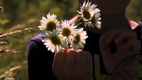 child holding a bouquet of daisies