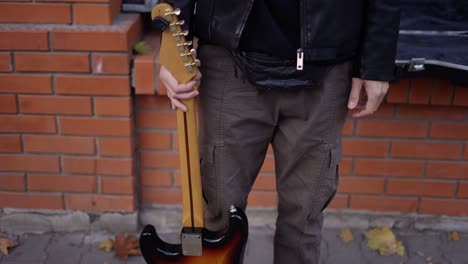 hombre con una guitarra sonriendo en la calle