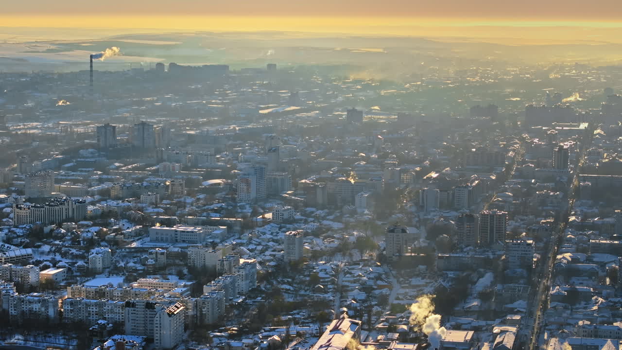Aerial drone view of Chisinau city covered in snow at sunset. Working thermal power station in background. Winter in Moldova