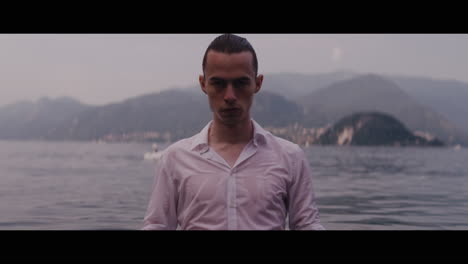 man in wet shirt by lake
