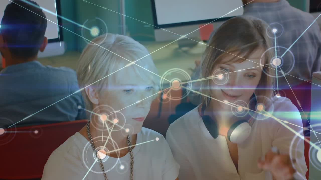 светящаяся сеть связей против двух белых женщин, использующих цифровой планшет в офисе