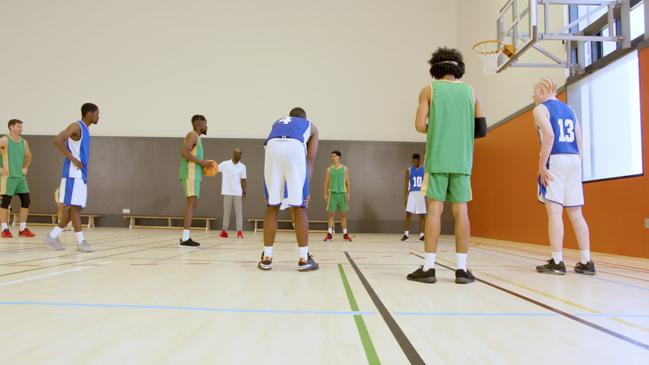 Giocatori di pallacanestro che si allenano ai tiri liberi in palestra, concentrandosi sul lavoro di squadra e sulle abilità.