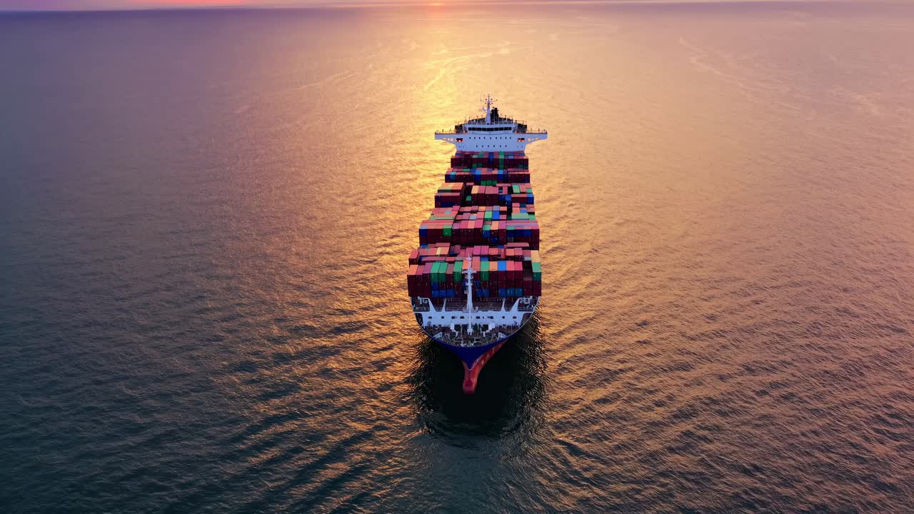 Aerial view of a cargo ship at sunset, showcasing vibrant containers. Ideal for a video on global