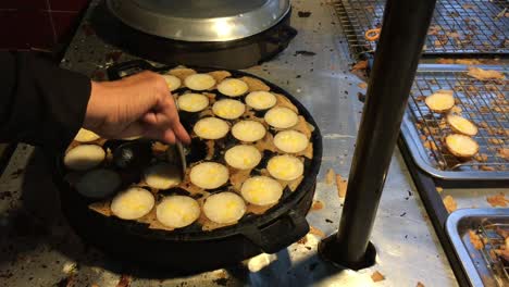 concepto de cocina. tipo de carne dulce tailandesa. leche de coco mezclada con postre frito en polvo en el mercado de comida callejera tailandés de la noche. postre de carne tradicional tailandesa, panqueque, pudín. imágenes de 4k.