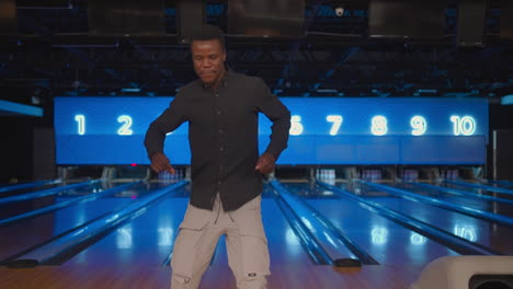 Black-African-American-man-Jump-happily-looking-at-the-camera-celebrate-the-victory-in-slow-motion.-Throw-in-the-bowling-alley-to-make-a-shoot.-Victory-dance-and-jump-with-happiness.