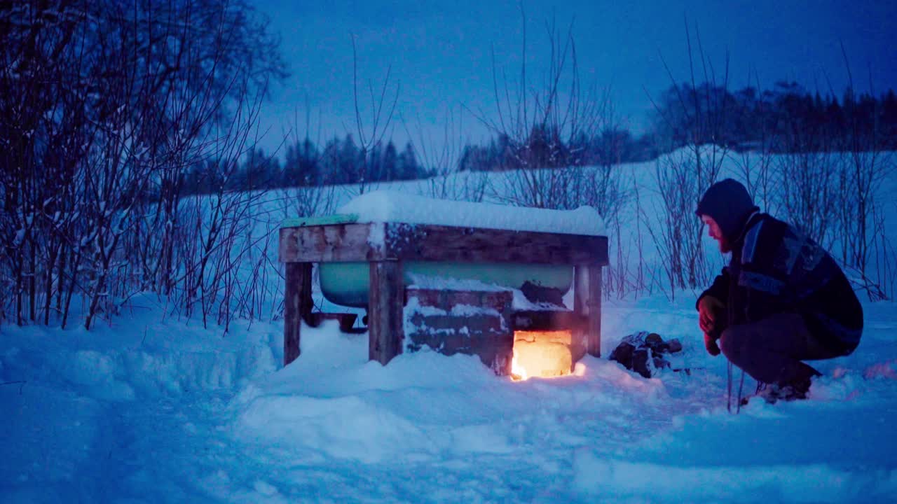 남자는 뜨거운 욕조 에 불을 켜서 가열합니다.
